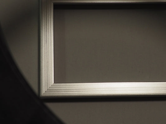 Empty ornate picture frame casting a shadow