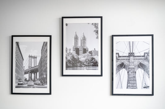 Three framed black and white cityscapes hang on wall