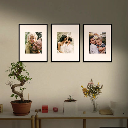 Three framed photographs of a family on a wall above a table with decorative items. Framiqa Gallery Wall Set